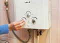 Men hand regulate the power of hot water in Gas water heater