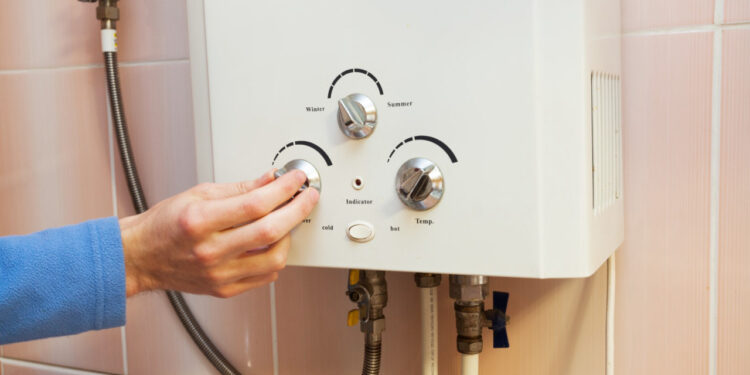 Men hand regulate the power of hot water in Gas water heater