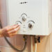 Men hand regulate the power of hot water in Gas water heater