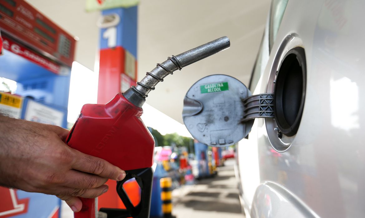 Imagem mostra carro sendo abastecido com combustíveis - gasolina