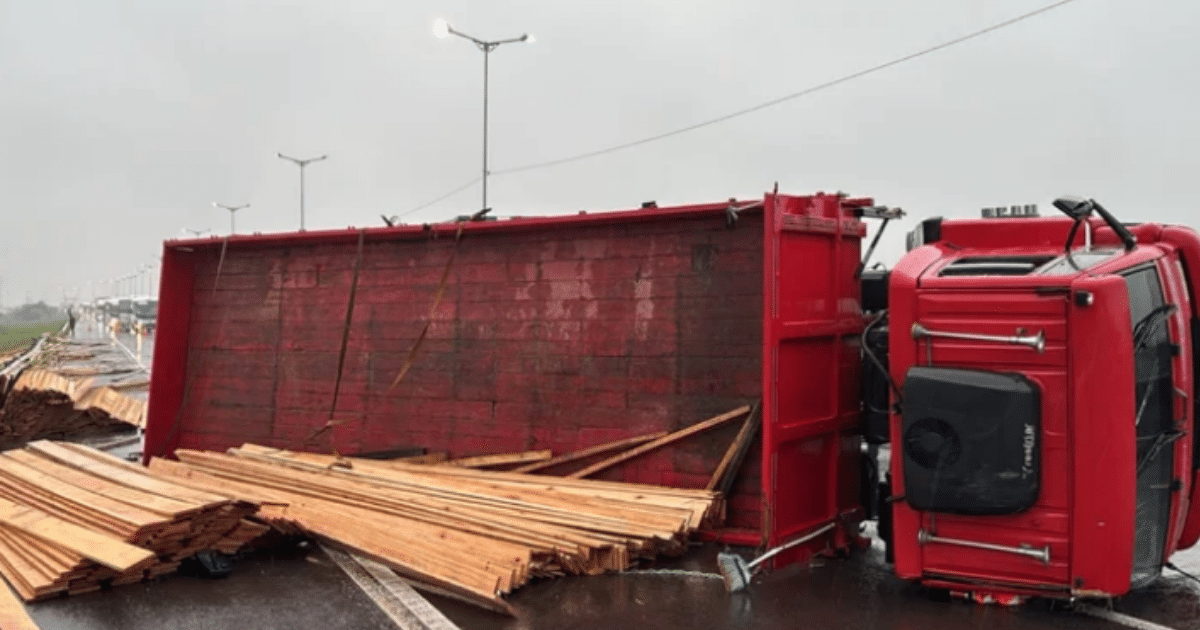 Caminhão carregado de madeira tomba e bloqueia duas faixas da Rodovia do Parque