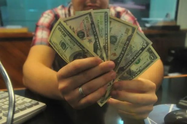 Dólar cede 1,55% com ajuda do exterior